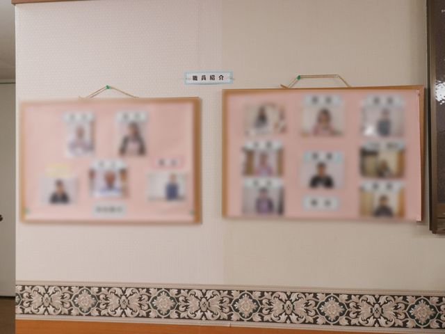 スタッフ紹介掲示板 職員紹介 温かみのあるカラーでまとめられた壁面にスタッフ紹介の掲示板が掲げられており、訪れる人々に安心を提供しています。