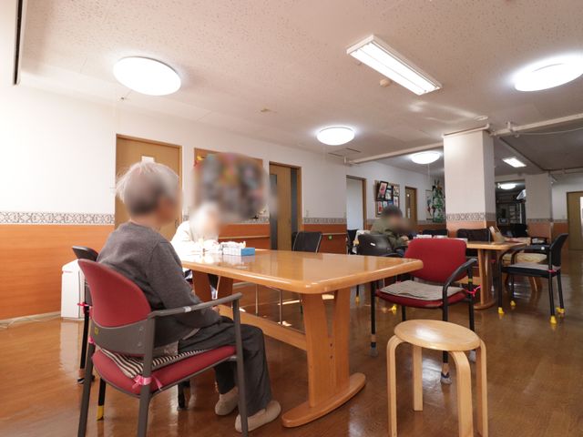 居心地の良い食堂 リビング 広々とした食堂で、ゆったりしたイスに座る方々の姿が見えます。日々の食事や憩いの時間を共にする温かな場所です。