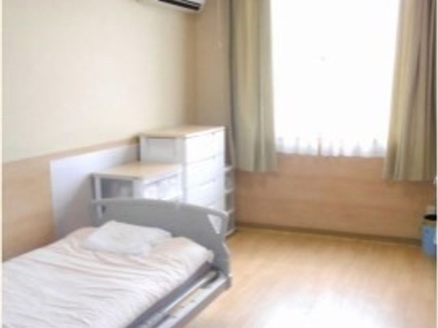 シンプルな個室の居室 居室 ゆとりある空間の個室です。明るい光が差し込む窓と、必要最低限の家具が配置されたシンプルなデザインが特徴です。
