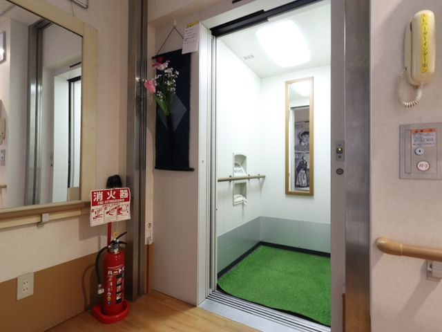エレベーターの入り口 エレベーター 花が飾られた心地よい空間のエレベーター入り口です。バリアフリー設計で、どなたでも安心してご利用いただけます。