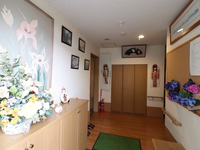 温かみのある廊下 玄関 アート作品と花で飾られ、心温まる雰囲気の廊下です。ここを通る毎日が、訪れる方々に安らぎを提供します。