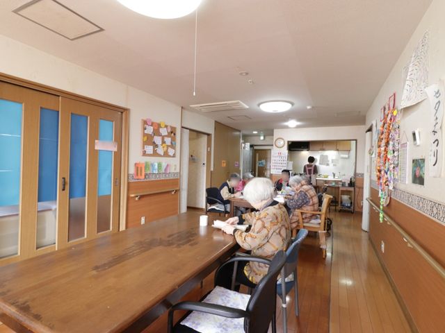 共有スペースと利用者 食堂 共有スペースでは、明るい光の下、利用者が食事や会話を楽しむ様子を見ることができます。温かい雰囲気が就業意欲を促します。