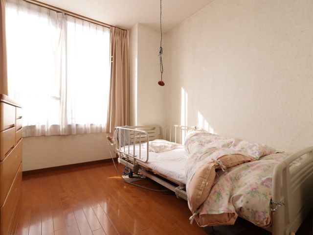 陽光差し込む明るい居室 居室 日差しの温もりを感じられる居室で、心地よいひとときをお過ごし頂けます。窓からの光が床材の木目を引き立て、落ち着いた雰囲気を醸し出しています。