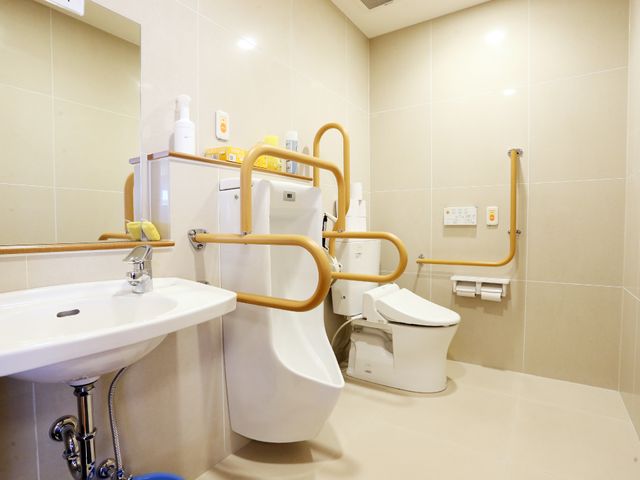 バリアフリー設計の浴室 トイレ 手すり付きの清潔感のあふれるトイレは、安全な利用を考えた設計です。利便性と安心を提供する設備が整っており、皆様の快適な就業環境を支えます。