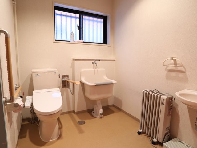バリアフリートイレ室内 トイレ 手すりと広々とした空間が確保された清潔なトイレです。利用者の快適な日常生活をサポートします。