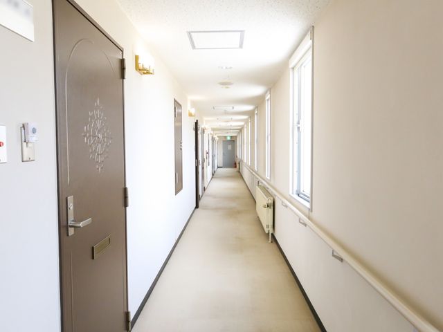 明るい廊下の風景 廊下 手すりが設置された清潔感のある廊下です。ゆったりとした幅で快適な移動が可能です。