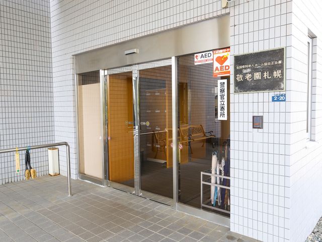 エントランスの明るい外観 玄関 ご来訪の際には、清潔感のある広々としたエントランスが皆様をお迎えします。安心のAEDも完備しております。