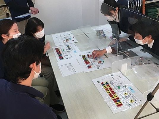 作業説明を囲む多人数の机  
