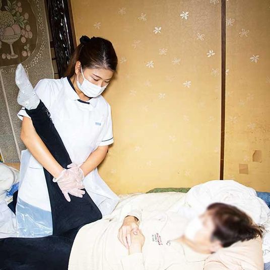 介護中のスタッフと利用者の居室