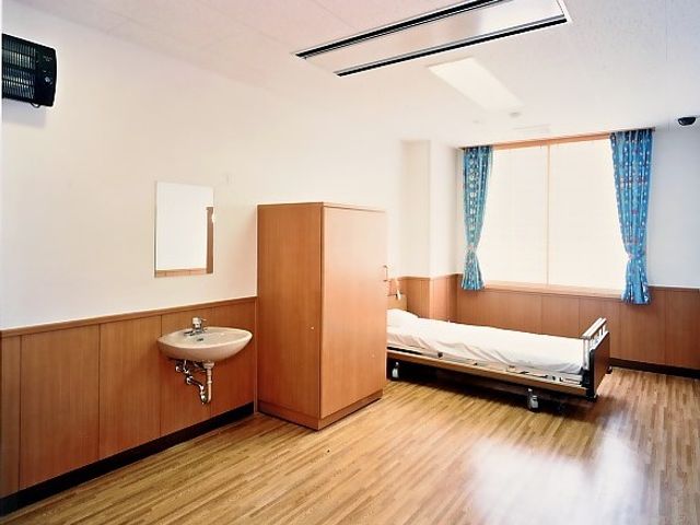 ベッドと洗面台の居室 居室 自然光が差し込む明るい居室です。ゆったりとした空間で快適に過ごせます。
