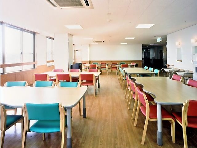 自然光が差し込むダイニングルーム ダイニングルーム 明るく広々とした空間で、ゆったりとした食事の時間を楽しめます。色とりどりの椅子が配置されています。