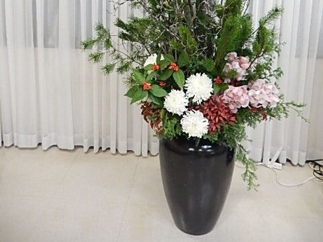 花の鉢があるロビー ロビー   大きな花の鉢が置かれた、落ち着いた雰囲気の空間です。来訪者をやさしく迎える印象で、働く場としても親しみやすさがあります。