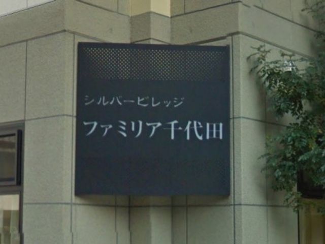 外壁に付いた案内看板 外観 温かみのある色合いで設計された外壁には案内看板が設置されており、訪れる人に明確な印象を与えています。
