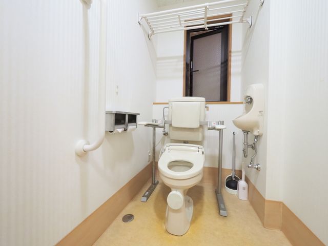 バリアフリー設計のトイレ ２つのトイレットペーパーフォルダー 手すり付きで安心感のある明るいトイレ空間です。利用者の安全と利便性を考えた配樹が特徴です。