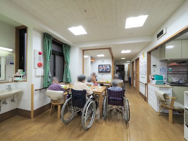 共有スペースで過ごす人々 食事スペース 車椅子を使用される方がゆったりと寛げる共有スペースです。日常のコミュニケーションを大切にした環境が整っております。