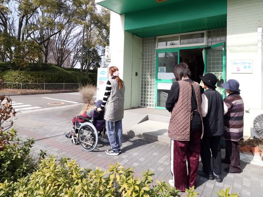 施設エントランスと来訪者