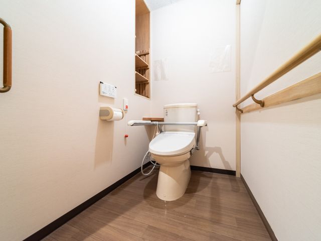 手すり付きのトイレ トイレ 安全な使い心地を考えた設計のトイレです。手すりが設置されていて、安定した支えを提供しています。