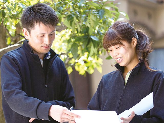 話し合うスタッフ画像 スタッフイメージ   スタッフ同士がリラックスした雰囲気で話し合っています。チームワークが求められる職場です。