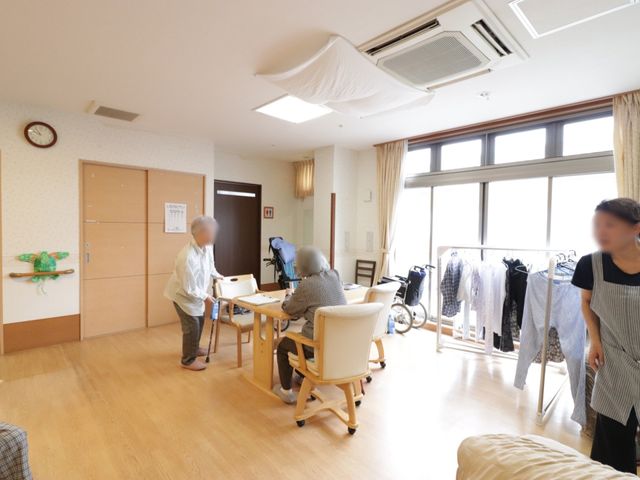 居室での日常風景 共有スペース ゆったりとした居室で、利用者が日々の生活を楽しんでいます。共有スペースも兼ね備え、コミュニケーションの場としても機能しています。