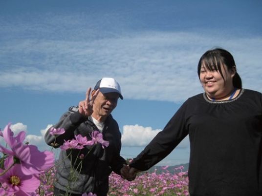 花畑で手をつなぐ人々