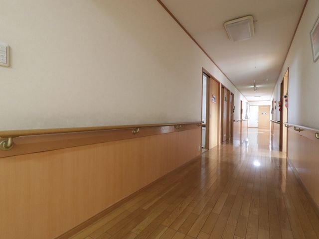 手すり付きの明るい廊下 通路 手すりが設置された広々とした廊下です。清潔感があり、安全に移動できるよう配慮されています。