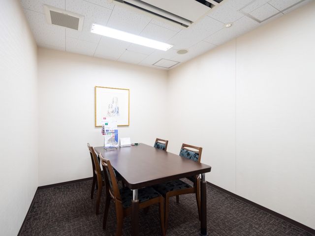 清潔なテーブルと椅子の部屋 談話室 落ち着いた色合いの部屋に整えられたテーブルセットが設置され、静かな雰囲気が漂います。
