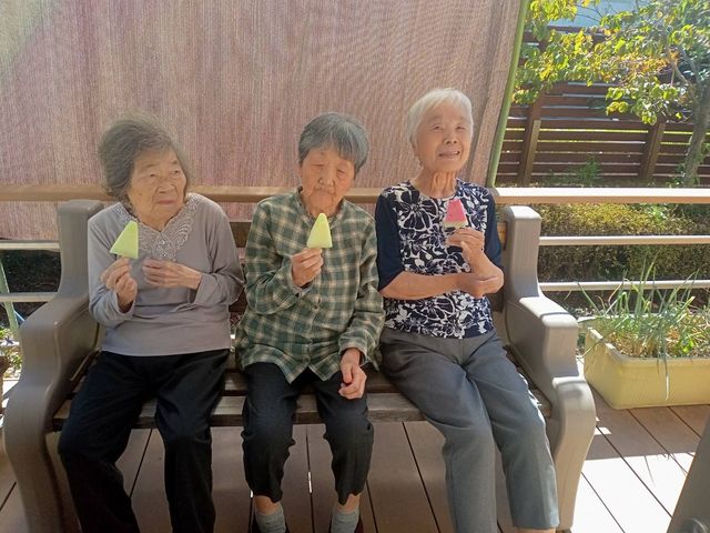 日差しの下で寛ぐ利用者の姿 テラス 心地よい自然光の中で、入居者様と共にくつろぐ時間をサポートできる職場です。