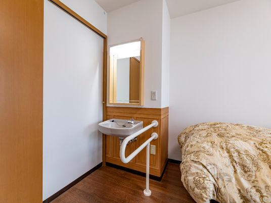 居室の洗面台とベッド
