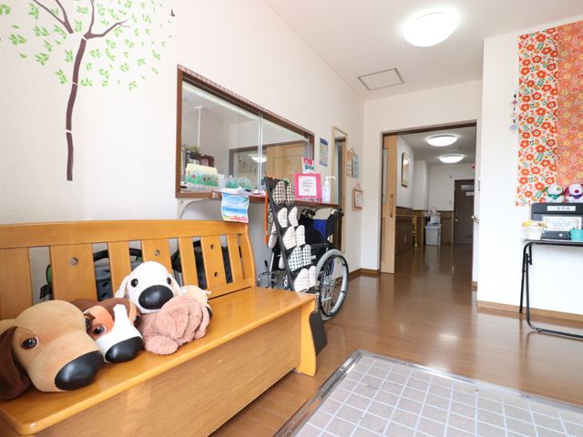 ぬいぐるみがある廊下 受付 明るく清潔感ある空間、壁には彩りを添える装飾があります。