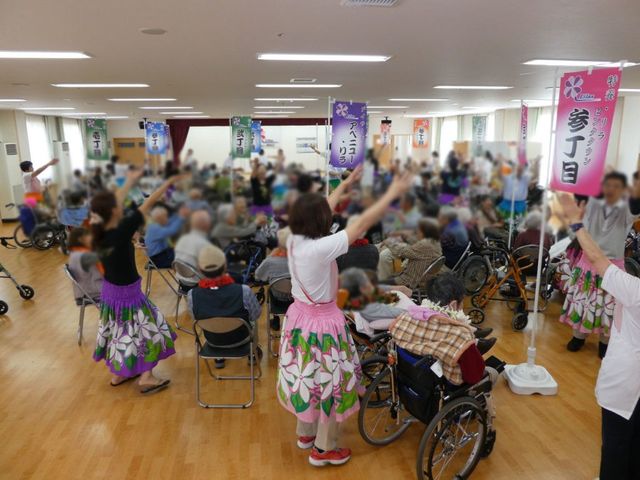 人々が集まる広間 多目的室 参加者たちが楽しく体を動かす様子が見られます。活気に満ちた空間です。