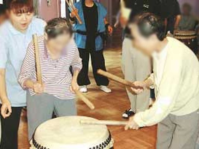 太鼓演奏の参加体験 機能訓練室 太鼓を使った演奏活動で、入居者の方々が生き生きとした時間を過ごしています。