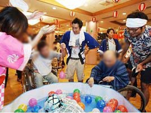 ボール遊びする場面 多目的室 楽しいイベントが行える活気あるスペースです。利用者の笑顔が広がっています。