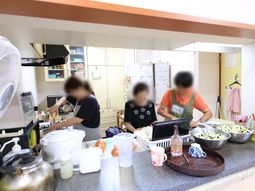 キッチンで料理する人々