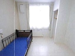 明るい居室のベッドと窓