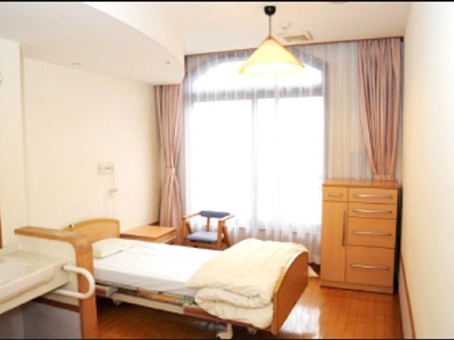 窓のある居室 居室 自然光が差し込む落ち着いた個室です。快適なベッドと収納スペースが整っています。