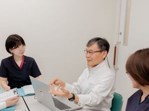 打ち合わせするスタッフと男性会議室  