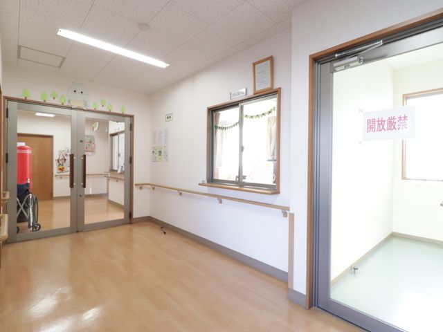 廊下に手すりと出入口 ロビー 広々とした廊下にはしっかりと手すりが備えられており、どなたでも安心して歩行ができる環境です。