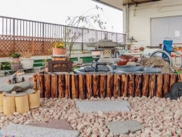 平和な雰囲気の庭 中庭 ゆったりとした中庭には、木の側面を活かしたテーブルがあり、植物に囲まれて安らぎの時間を過ごせます。