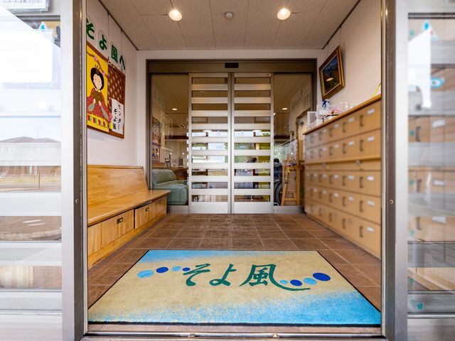 エントランスの明るい風景 玄関 待合スペースを備えたアクセスしやすいエントランスです。温かみのあるデザインが訪れる人をやさしく迎え入れます。