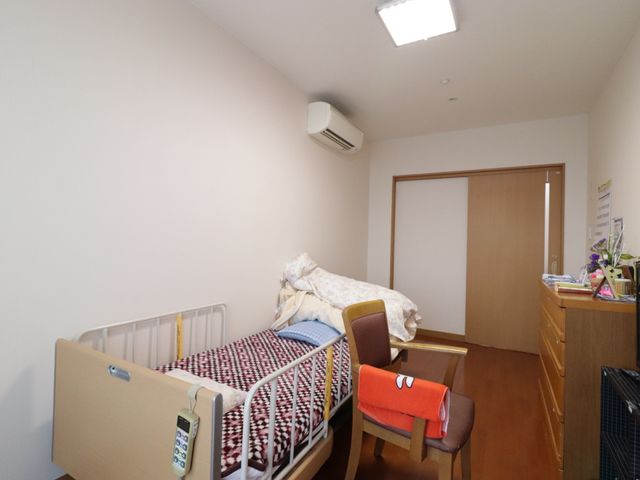 居室のベッドとデスク 居室 居心地のよい個室で、必要な物が整う落ち着いた環境です。個々のニーズに合わせた空間がこちらの施設の特徴です。