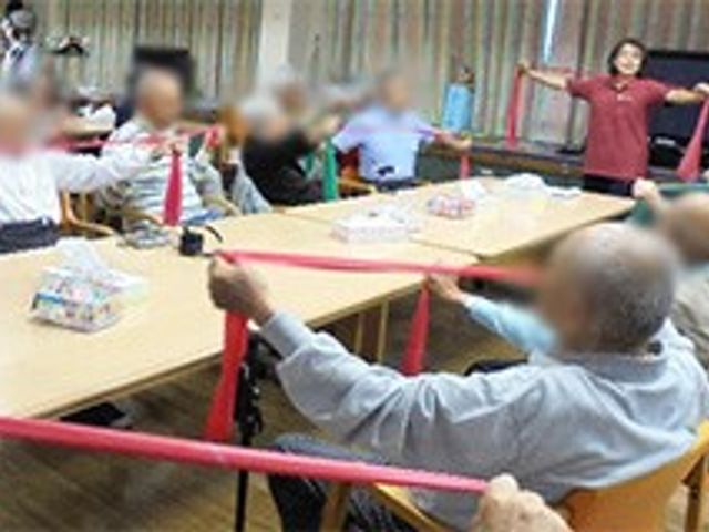 運動を行う室内 機能訓練室 明るい空間で、参加者がリラックスしてエクササイズを楽しんでいます。