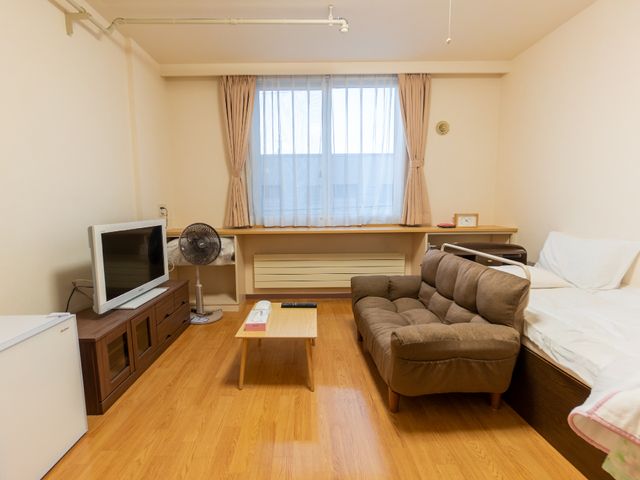 居心地の良い居室の様子 居室 落ち着いた雰囲気の個室で、ソファやテレビが完備され快適な休息がとれます。窓からは自然光が差し込み、居室内が明るく照らされております。