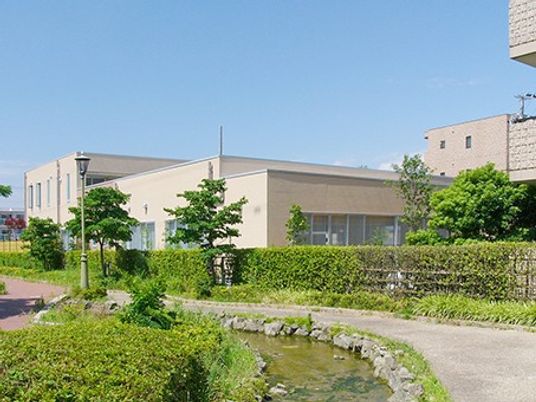 緑に囲まれた建物の外観  