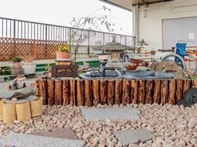 中庭の水鉢と石庭 中庭   石を敷いた落ち着いた中庭に、水鉢と小さな植栽が並んでいます。ゆったりした雰囲気で、働く方も気分転換しやすそうです。