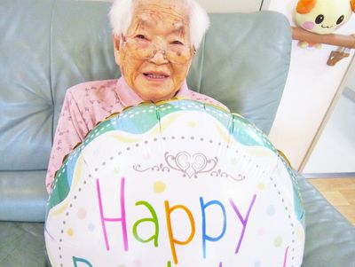 お祝い風船と高齢女性