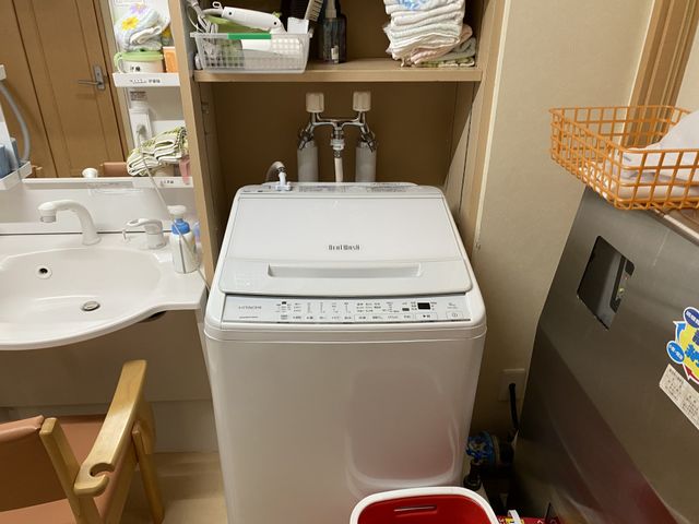 洗濯機と洗面所の内観 洗面台 清潔感のある洗面台周辺の様子です。共用の洗濯機も備えており、日々の生活が快適に過ごせる設備です。