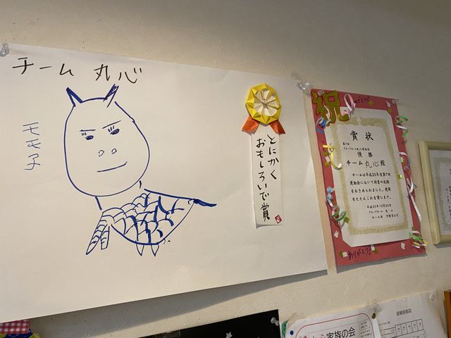 壁掛けの手作り掲示物 掲示物 手作り感溢れる温かみのある掲示物が、壁に飾られていて、訪れる方々に安らぎを提供しています。