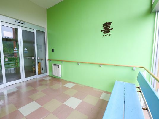 緑色の壁と手すりの廊下