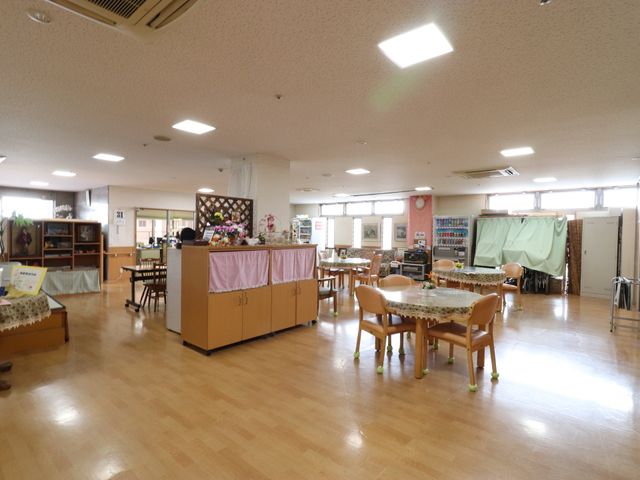 ゆったりした共有スペース ホール 広々とした明るい食堂で、入居者の皆さまが食事や憩いの時間を過ごされています。利用者思いの配慮が光る環境です。