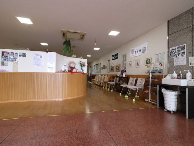 受付と掲示物のあるロビー 玄関 整理された掲示物と受付カウンターが設けられた、明るく清潔な空間です。何かと便利なロビーの様子をご覧いただけます。